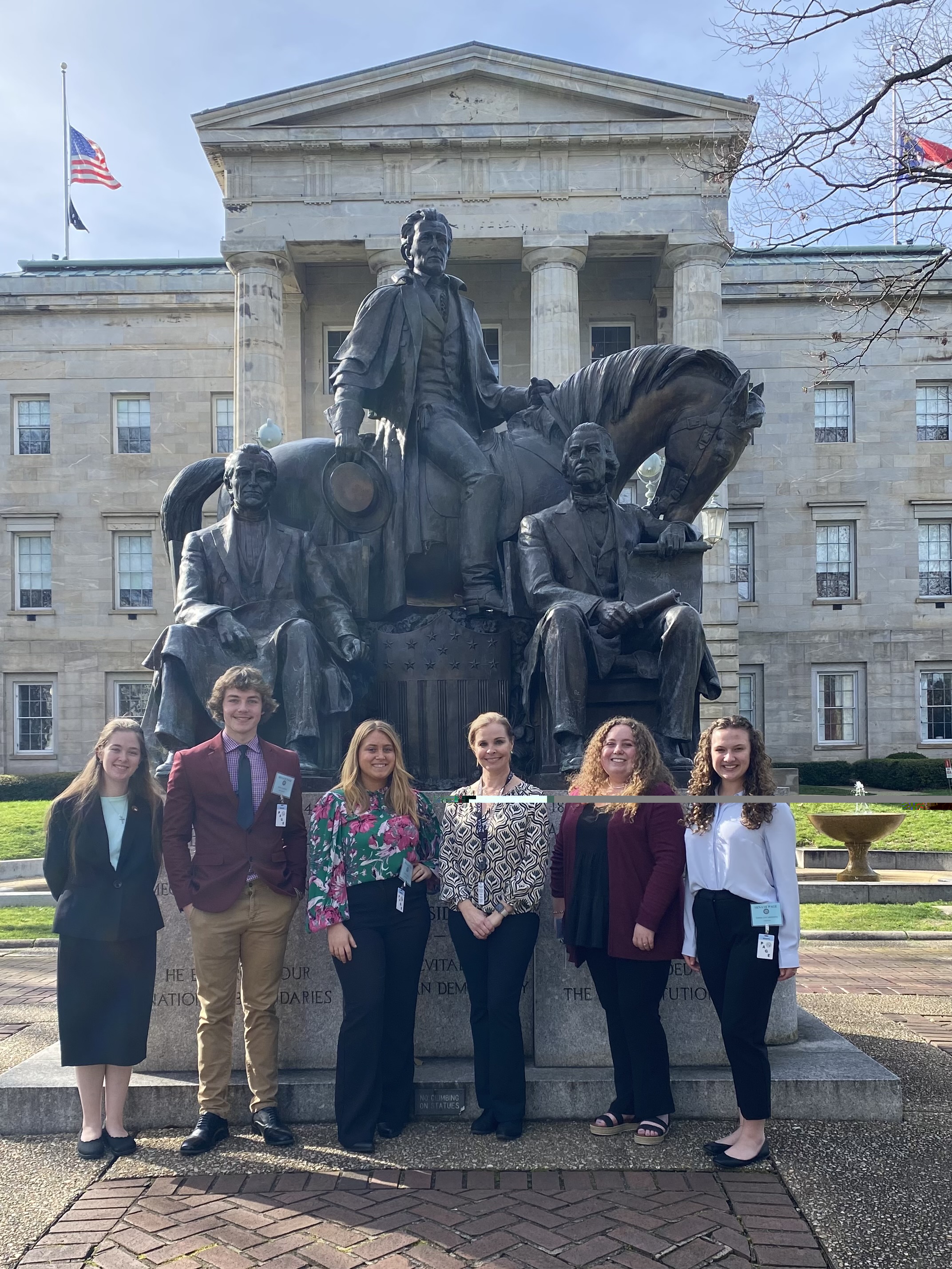 Senate Pages standing next to statue of three US presidents at the state capitol.